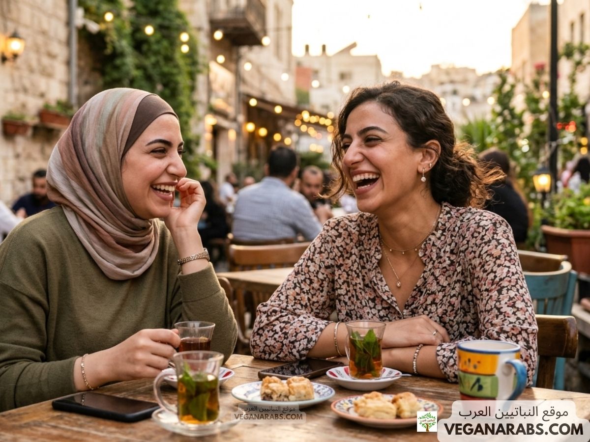 Two women share a joyful moment at an outdoor café, with tea and pastries on the table. The street is bustling and warmly lit in the background.